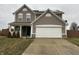 Two-story house with taupe vinyl siding, a white garage door, and a well-maintained lawn at 672 Rocky Meadow Dr, Greenwood, IN 46143