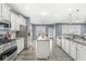 Modern kitchen boasts stainless steel appliances, granite countertops, and white cabinetry at 7648 Three Arch Overlook, Noblesville, IN 46062