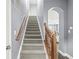 Carpeted staircase with wooden handrail leading upstairs at 7648 Three Arch Overlook, Noblesville, IN 46062