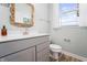 Powder room with gray vanity, white toilet, and wood-look flooring at 16222 Browning Ct, Fishers, IN 46037