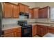 Modern kitchen with black appliances and wood cabinets at 4845 Ventura Blvd, Plainfield, IN 46168