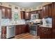 Modern kitchen with dark wood cabinets, granite counters, and stainless steel appliances at 5584 E Fountain Way, Columbus, IN 47201