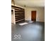 Simple living room with exposed log wall and gray floor at 5967 S Lick Creek Rd, Morgantown, IN 46160