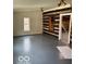 Spacious living area featuring log walls and a gray floor at 5967 S Lick Creek Rd, Morgantown, IN 46160