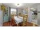 Bright dining room features hardwood floors, wood chairs, and a view into the kitchen at 6018 Thrushwood Dr, Indianapolis, IN 46250