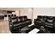 Living room with black leather reclining sofas, and a patterned rug at 6329 Basden Dr, Indianapolis, IN 46221