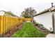 Landscaped backyard with a wooden fence, lush grass, and mature plants at 6785 Settlement S Dr, Indianapolis, IN 46250