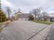 Three-car garage with a large concrete driveway offering ample parking space at 8530 Bluefin Cir, Indianapolis, IN 46236