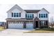 Two-story home with white siding, brick accents, and a three-car garage at 2400 Oakmont Dr, Plainfield, IN 46168