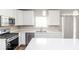 Modern kitchen with white cabinets, stainless steel appliances, and quartz countertops at 2400 Oakmont Dr, Plainfield, IN 46168
