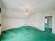 Spacious attic bedroom with green carpet and access to another room at 2439 N Kenwood Ave, Indianapolis, IN 46208