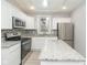 Updated kitchen featuring white cabinets, granite countertops, and stainless steel appliances at 3180 Graceland Ave, Indianapolis, IN 46208