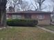 Brick ranch house with a landscaped lawn and walkway at 3241 N Riley Ave, Indianapolis, IN 46218