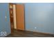 Bedroom with light blue walls, wood-look flooring, and an open door at 3301 Cessna Dr, Columbus, IN 47203