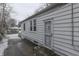 Rear view of a white house with a security door and snowy yard at 3525 N Olney St, Indianapolis, IN 46218