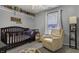 Adorable Bedroom features a crib, recliner, and ample shelving at 3917 St Simons Ct, Indianapolis, IN 46237