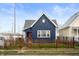 Charming blue house with a red door, wooden fence, and well-manicured lawn at 413 E Caven St, Indianapolis, IN 46225