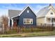 Charming blue house with a red door, wooden fence, and well-manicured lawn at 413 E Caven St, Indianapolis, IN 46225