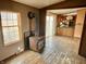 Living room with wood stove, wood-look floors, and view into kitchen at 4726 E 210 N, Lebanon, IN 46052