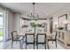 Bright dining area with farmhouse table and view of the kitchen and backyard at 595 Bluestem Ln, New Whiteland, IN 46184