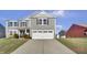 Two-story gray house with white garage door and landscaping at 2034 Buckthorn Dr, Columbus, IN 47201