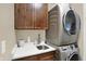 Modern laundry room with stacked washer and dryer, cabinets, and a sink at 4621 N Meridian St, Indianapolis, IN 46208