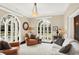 Sunroom with arched doors and windows, leather seating, and a view of the backyard at 4621 N Meridian St, Indianapolis, IN 46208