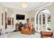 Bright sunroom with arched French doors opening to a patio, leather armchairs, and a flat-screen TV at 4621 N Meridian St, Indianapolis, IN 46208
