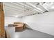 Unfinished basement with a sectional sofa and white painted walls at 4817 Welton St, Greenwood, IN 46143