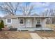 Cute bungalow with covered porch, landscaping, and a charming front yard at 4902 W Raymond St, Indianapolis, IN 46241