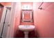 Small bathroom with pedestal sink and ornate mirror at 7589 Willow Rdg, Fishers, IN 46038