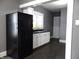 White cabinets, black appliances, and dark grey floors at 1314 Arrow Ave, Anderson, IN 46016