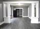 Grey walls, dark grey floors, and white columns separating the living and dining areas at 1314 Arrow Ave, Anderson, IN 46016