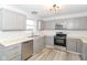 Modern kitchen with gray cabinets, stainless steel appliances, and hardwood floors at 6530 Waterloo Ln, Indianapolis, IN 46268