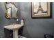 Stylish powder room with a pedestal sink, ornate mirror, and Parisian decor at 8053 Hopkins Ln, Indianapolis, IN 46250