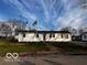 White Ranch style home with American and another flag at 5233 S Vine St, Columbus, IN 47201