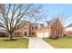 Brick two-story home with three-car garage and landscaped lawn at 12540 Sandstone Run, Carmel, IN 46033