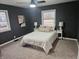 Well-lit bedroom with dark walls, neutral bedding, and hardwood floors at 1521 E Buchanan St, Plainfield, IN 46168