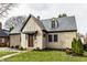 Tan house with gray roof, dark wood door, and manicured lawn at 5858 N Delaware St, Indianapolis, IN 46220