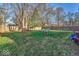 Large backyard with grassy area, wooden fence, and playset at 637 Holiday Dr, Fortville, IN 46040