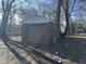 Gray detached garage with a single car door, nestled among trees at 715 N Warman Ave, Indianapolis, IN 46222