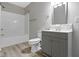 Updated bathroom with gray vanity, white subway tile, and vinyl flooring at 1101 W Roache St, Indianapolis, IN 46208