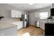 Modern kitchen with white cabinets, stainless steel appliances and breakfast bar at 1101 W Roache St, Indianapolis, IN 46208