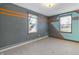 Bedroom with gray and teal walls, carpet flooring, and two windows at 308 E 36Th St, Anderson, IN 46013