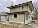 Rear view of a two-story house with gray siding, new windows, and a metal roof at 3563 Carrollton Ave, Indianapolis, IN 46205