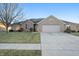 Brick ranch home with attached two-car garage and landscaped lawn at 5101 W Quincy Ct, Columbus, IN 47203