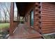 Log cabin exterior with a wooden porch and green door at 5360 N Carroll Rd, Indianapolis, IN 46235