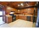 Kitchen boasts wood cabinets, black appliances, and tile flooring at 5360 N Carroll Rd, Indianapolis, IN 46235