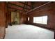 Living room with wood walls, large window, and wood-burning stove at 5360 N Carroll Rd, Indianapolis, IN 46235
