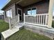 Brick home with spacious back patio, white railing, and access from sliding glass door at 5375 E Commons West Dr, Mooresville, IN 46158
